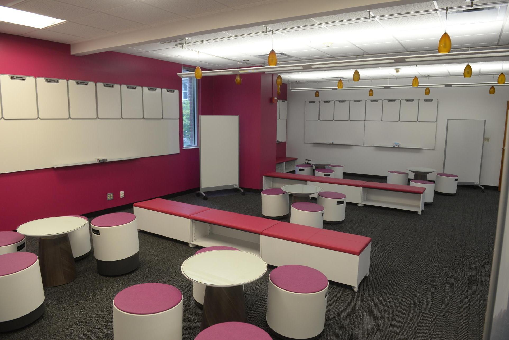 interior of the CoLab, pink and white furniture with gray carpeting