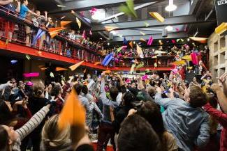 a group of students throwing colorful paper airplanes